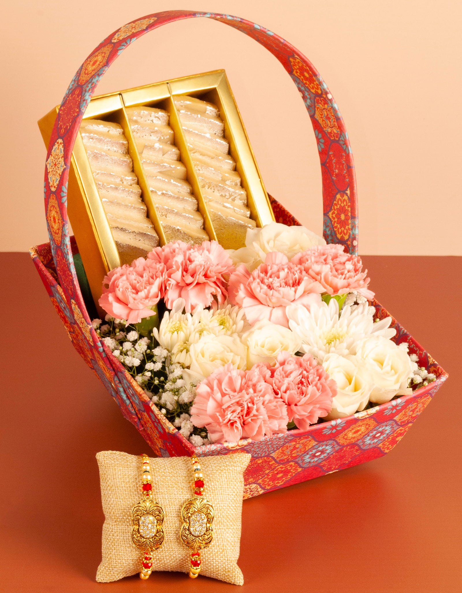 flower delivery pune - pink and white flowers, and sweet box arranged in a paper basket with rakhi