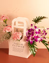 flower bouquet online - light pink carnations and purple orchids arranged in paper bag