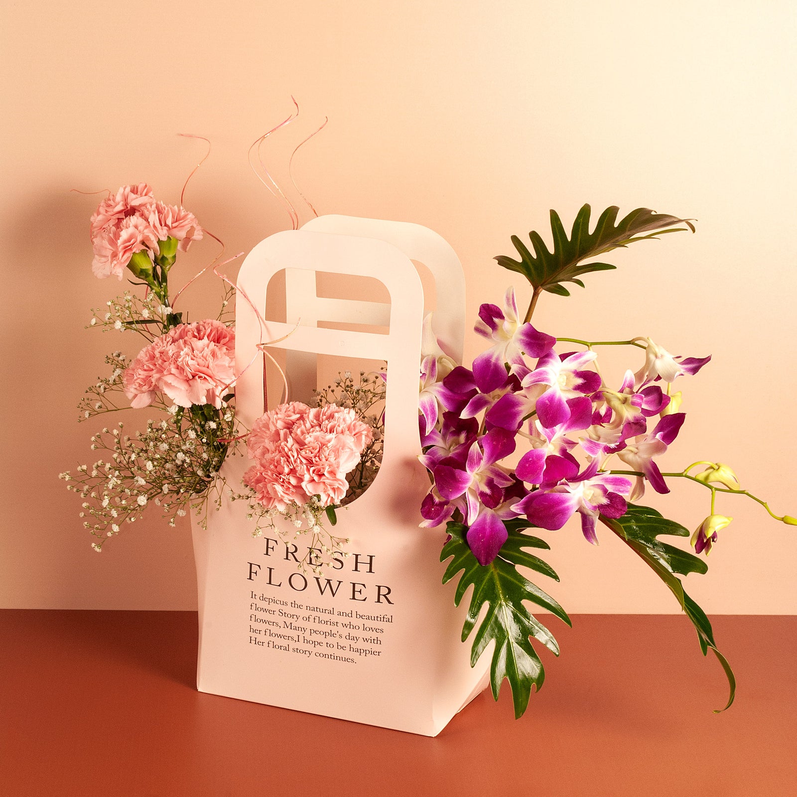 flower bouquet online - light pink carnations and purple orchids arranged in paper bag