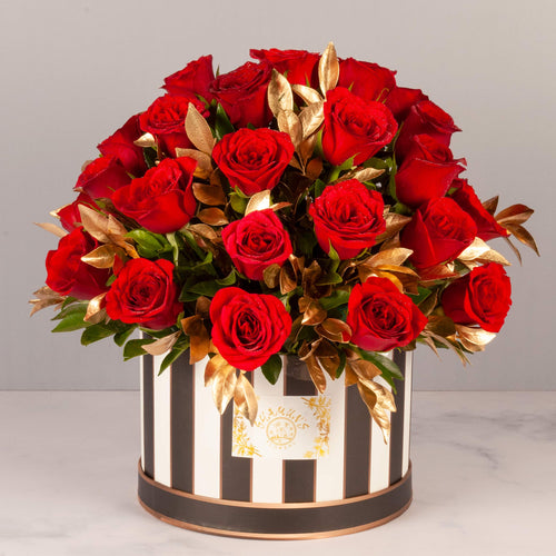 flower bouquet near me - red roses and gold leaves arranged in a striped box